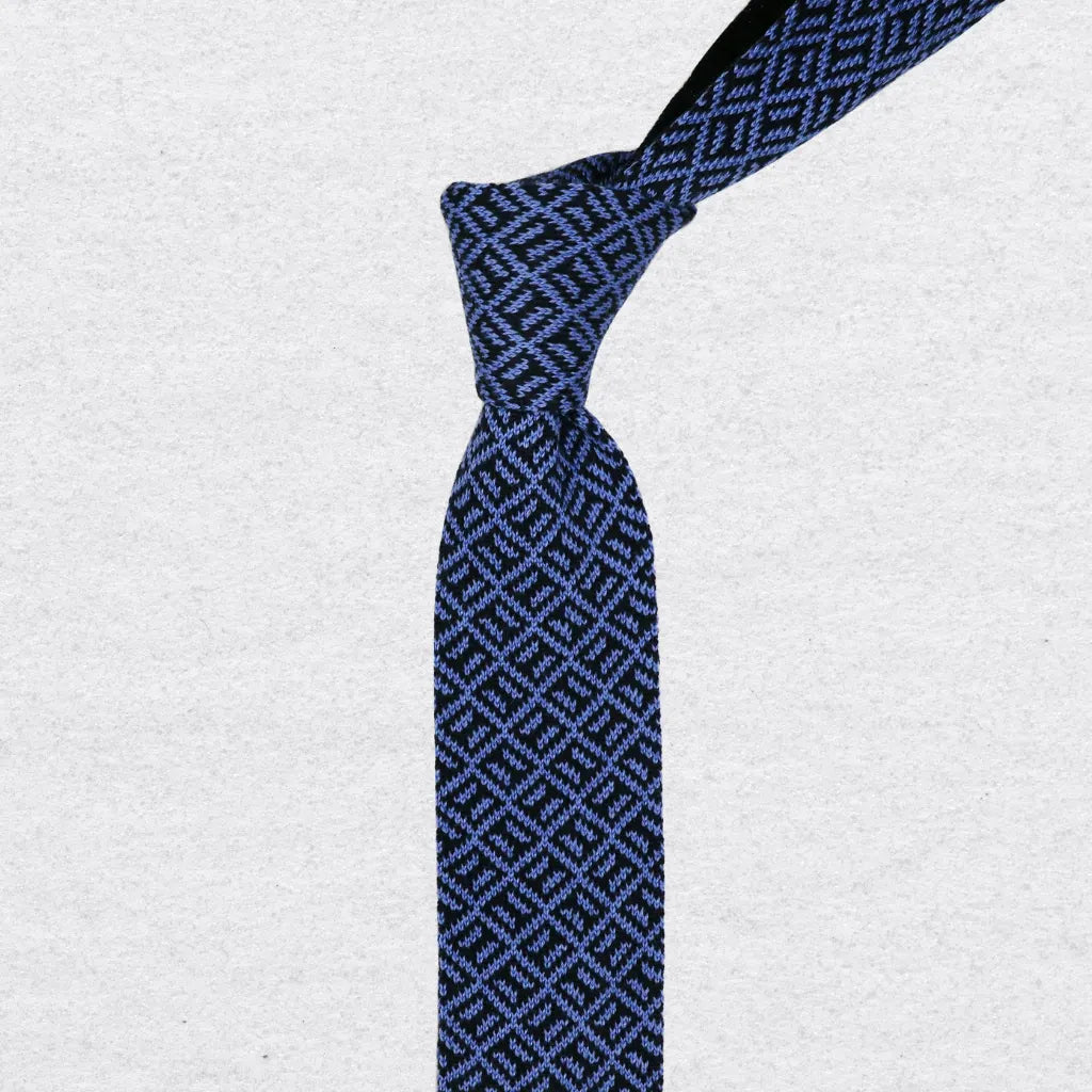 Navy and sky blue patterned knitted tie on a textured background