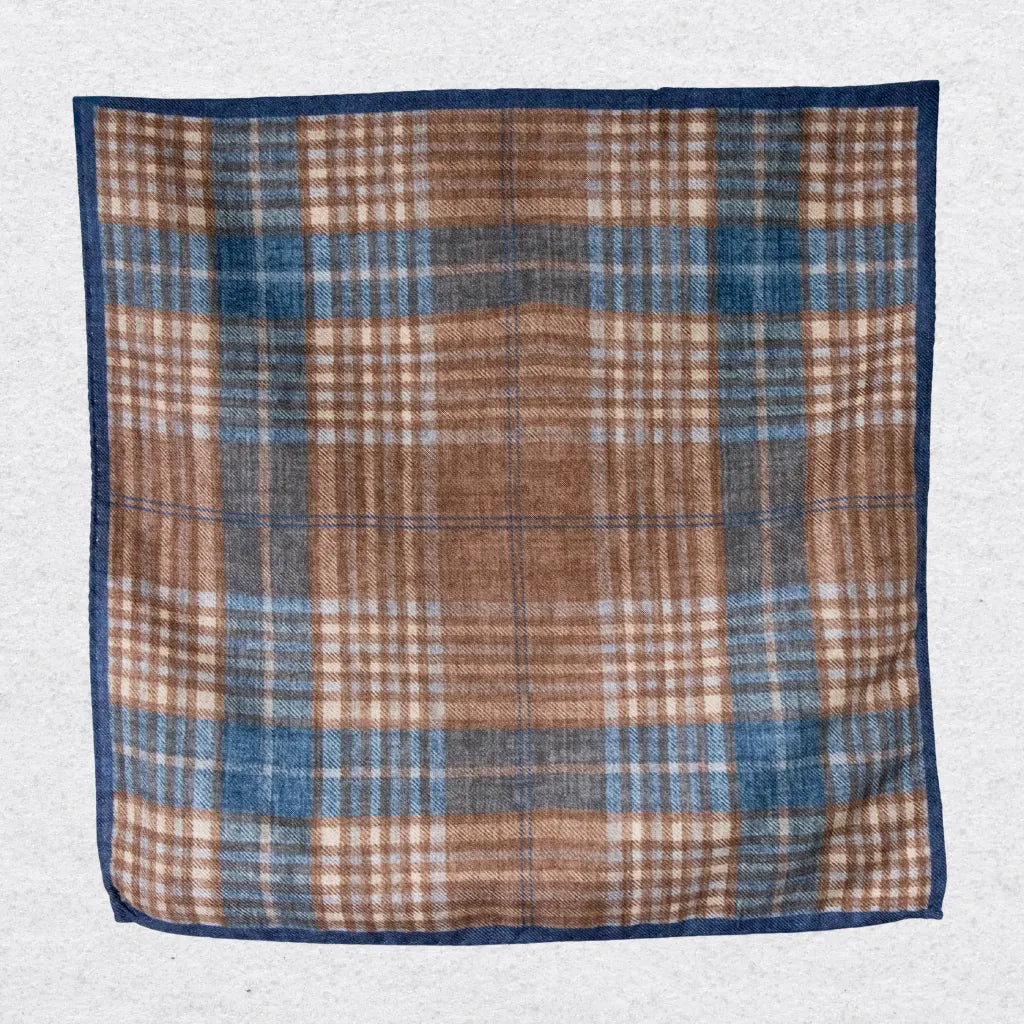 Plaid wool pocket square with brown, blue, and beige colors on a light gray background