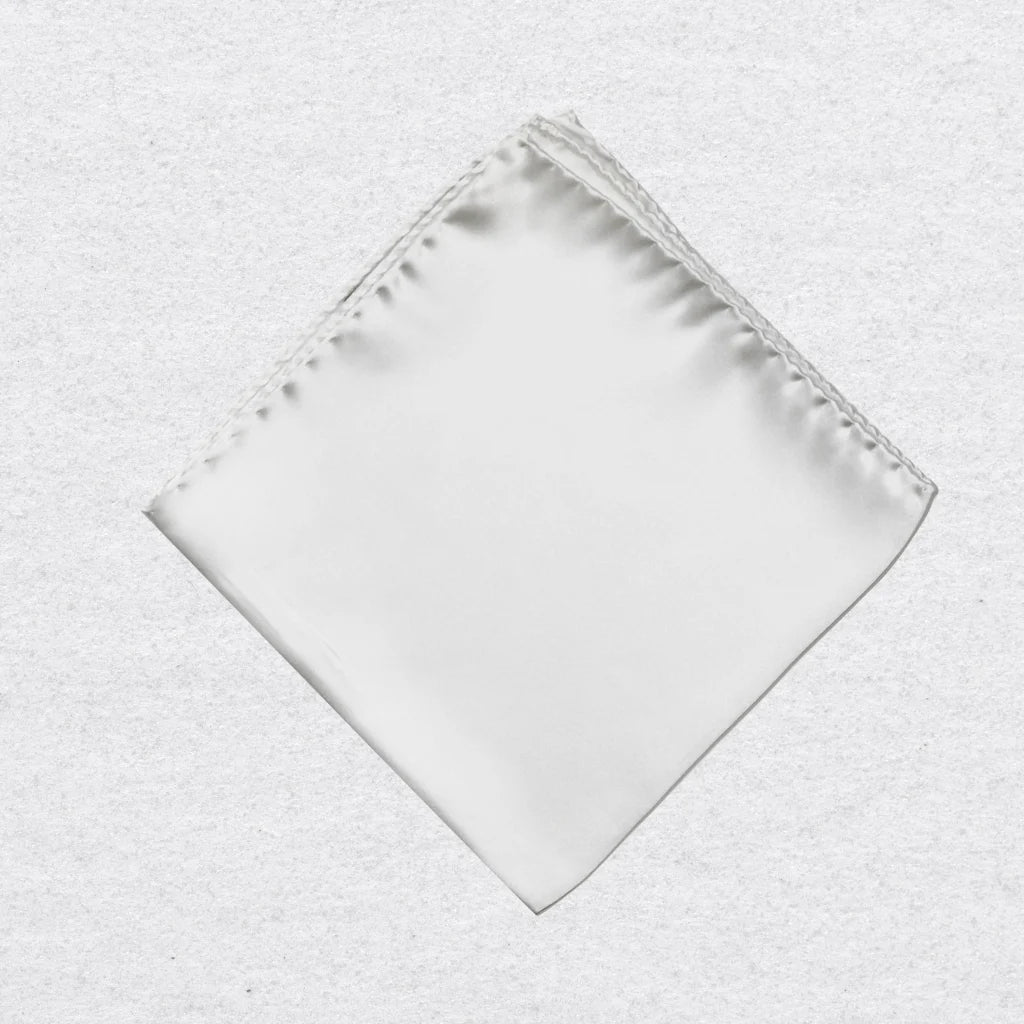 White silk pocket square on a textured grey background
