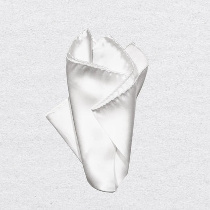 White silk pocket square pinched into a point on a grey background
