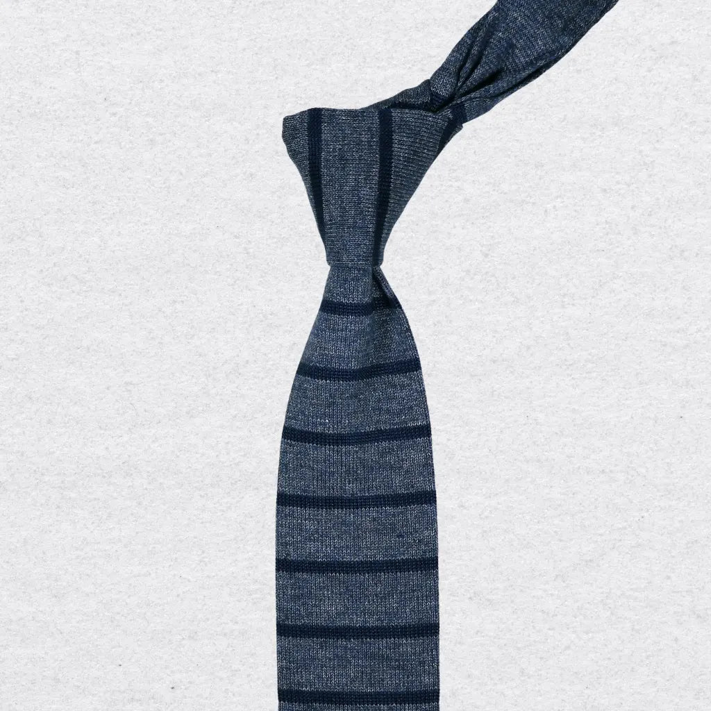 Blue striped knitted tie on a textured background