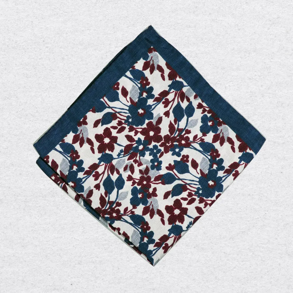 Navy floral patterned silk pocket square on a grey background