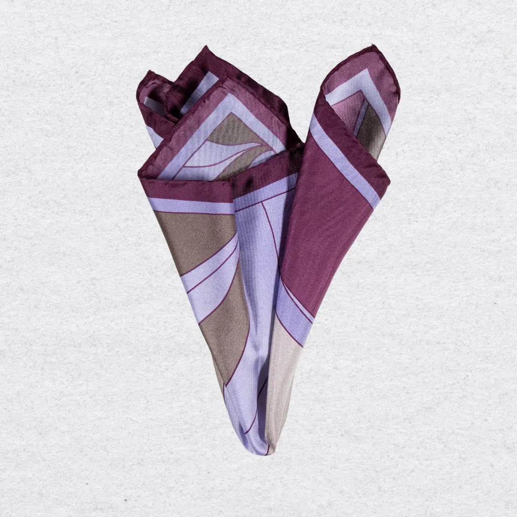 Folded pocket square with purple geometric pattern on a grey background