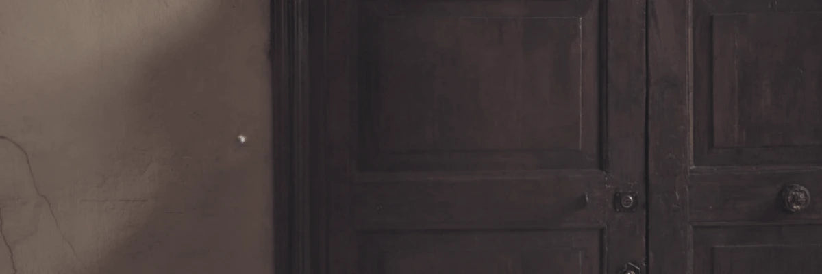 Close-up of a rustic wooden door and plaster wall