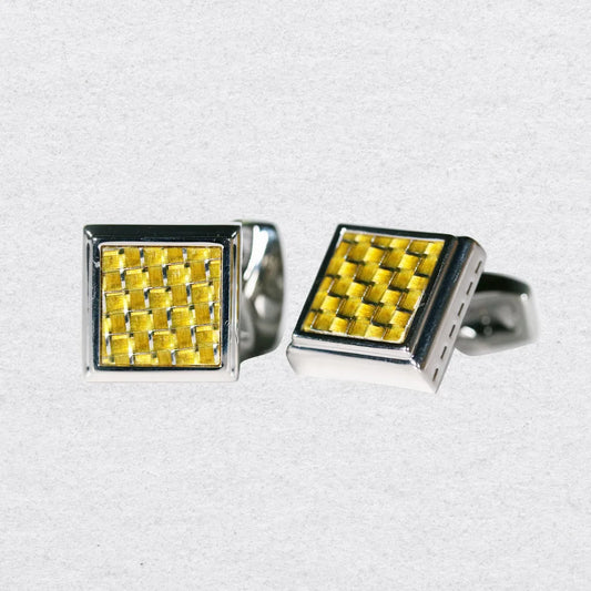 Pair of square cufflinks with gold woven pattern and silver border on a grey background