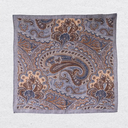 Paisley patterned linen pocket square in grey and tobacco brown hanging against a grey background