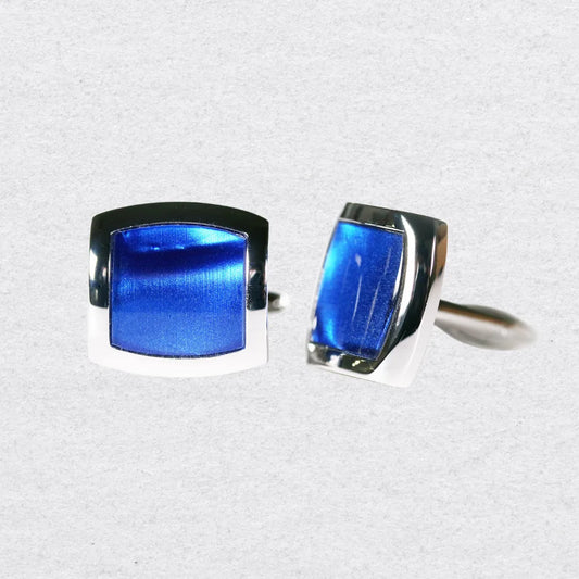 Pair of blue cufflinks with silver setting on a grey background