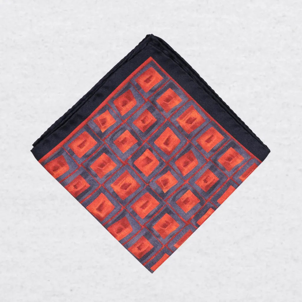 Folded orange and blue silk pocket square with geometric pattern