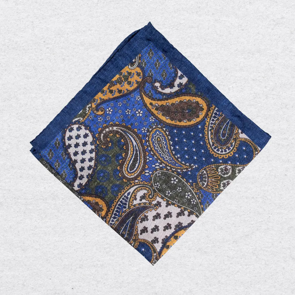 Blue pocket square with paisley pattern on a grey background