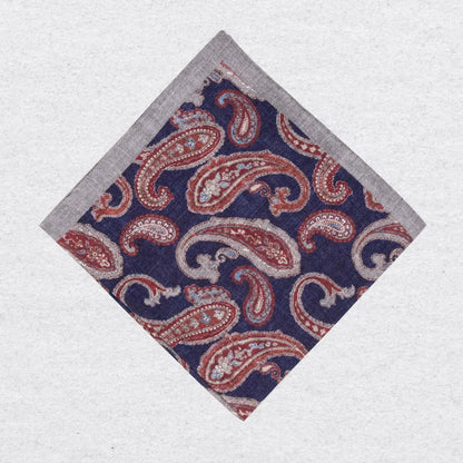 Paisley patterned linen pocket square in navy and rust on a white background