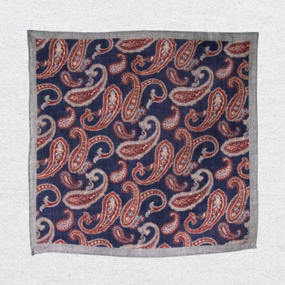 Hanging linen pocket square with paisley pattern and grey border on a white background