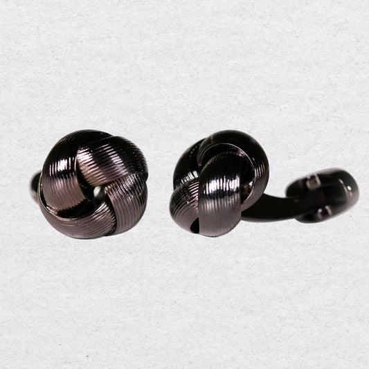 Pair of polished gunmetal knot cufflinks on a grey background