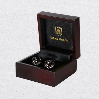 Polished gunmetal knotted cufflinks displayed in a wooden Monti Castello box