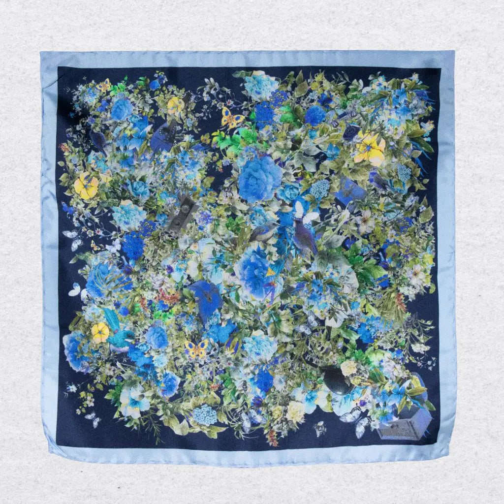 Floral patterned silk pocket square with blue and green colors on a grey background