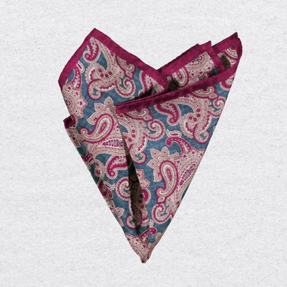 Red and blue paisley patterned silk pocket square on a grey background