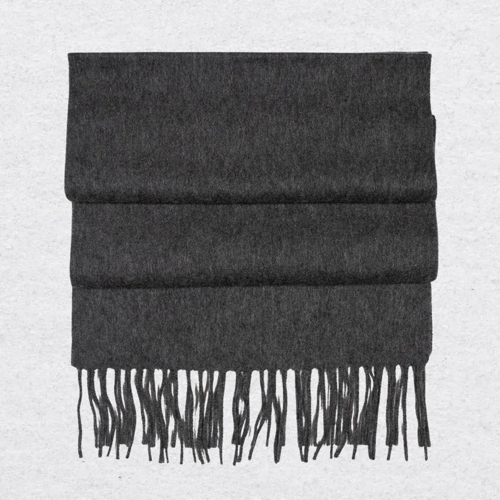 Dark gray cashmere scarf with tassels on a light gray background