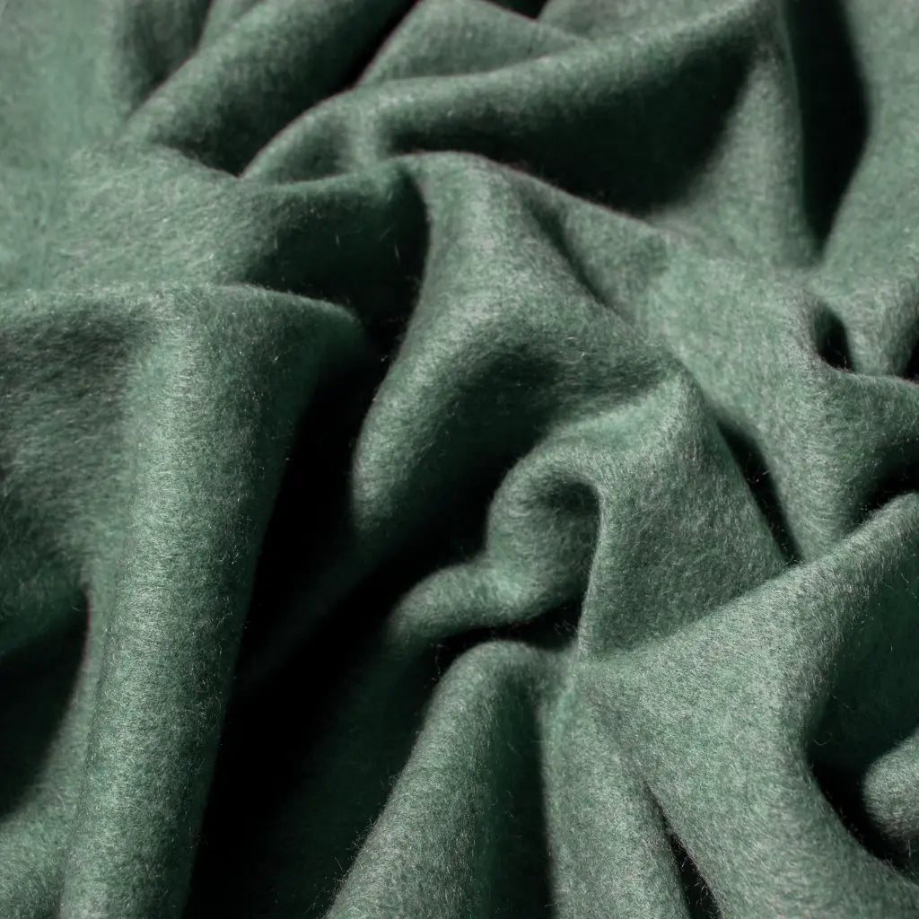 Close-up of rich forest green cashmere fabric with folds