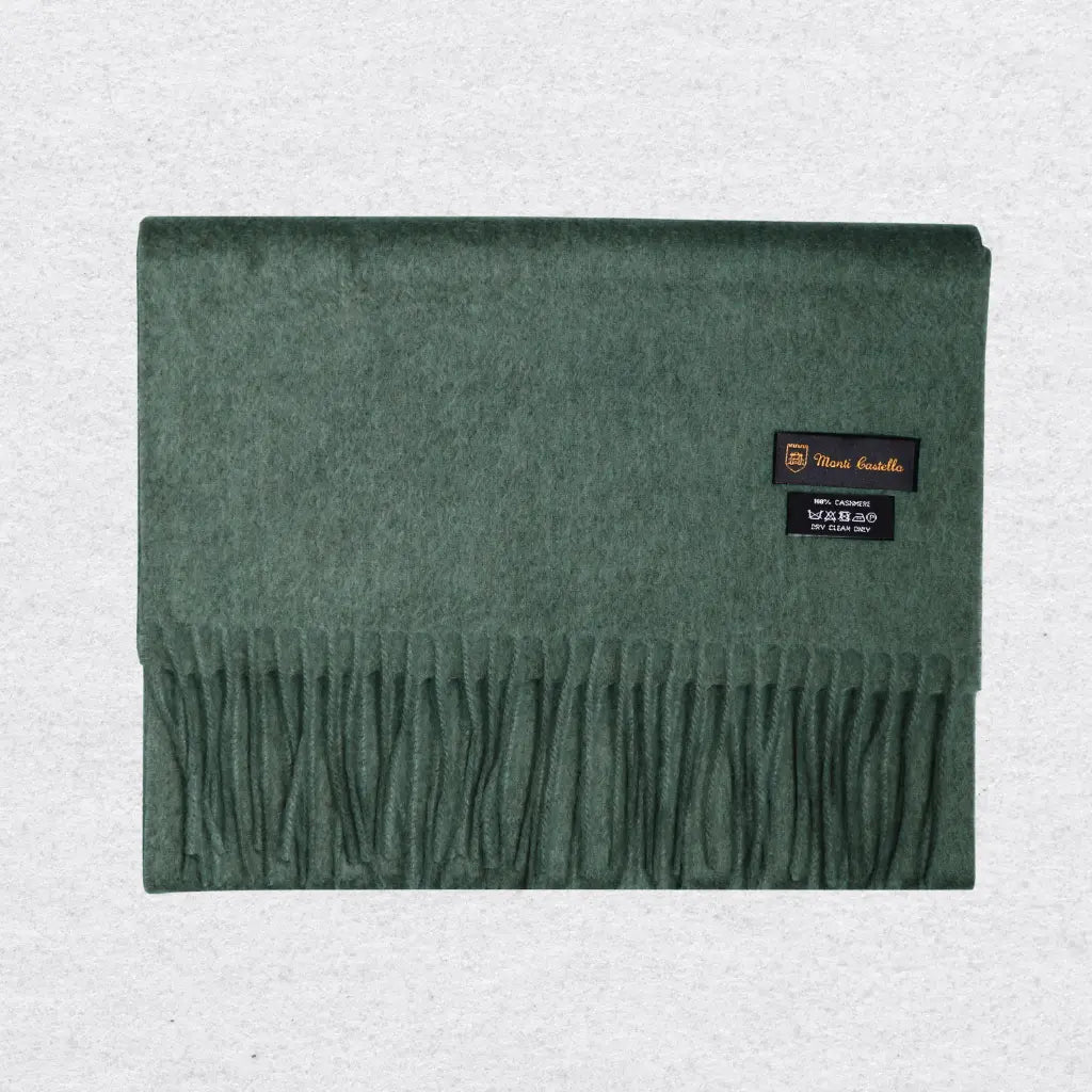 Green cashmere scarf with Monti Castlello brand labels on a light gray background