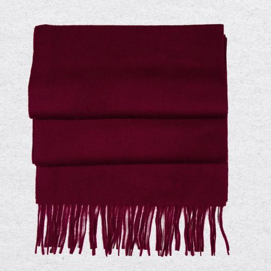 Burgundy cashmere scarf with tassels on a light gray background