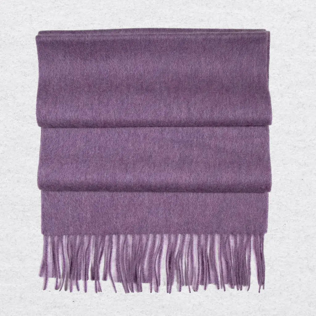 Purple cashmere scarf with tassels on a light gray background