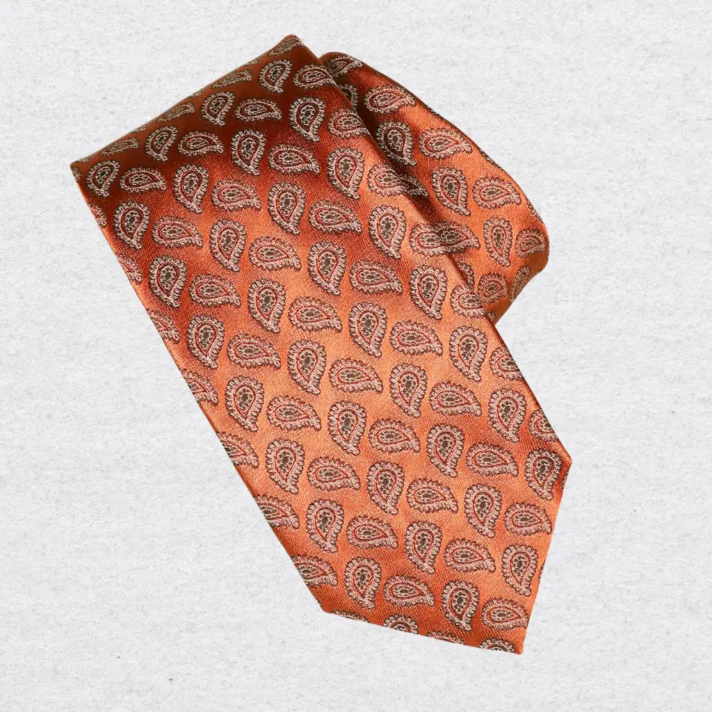 Orange paisley patterned tie on a white background