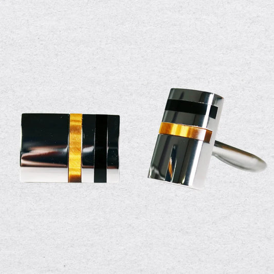 Tiger's Eye cufflinks with black, gold, and silver design on a grey background