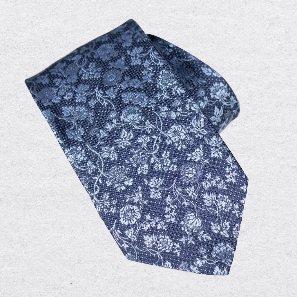 Blue floral patterned Italian silk tie on a white background
